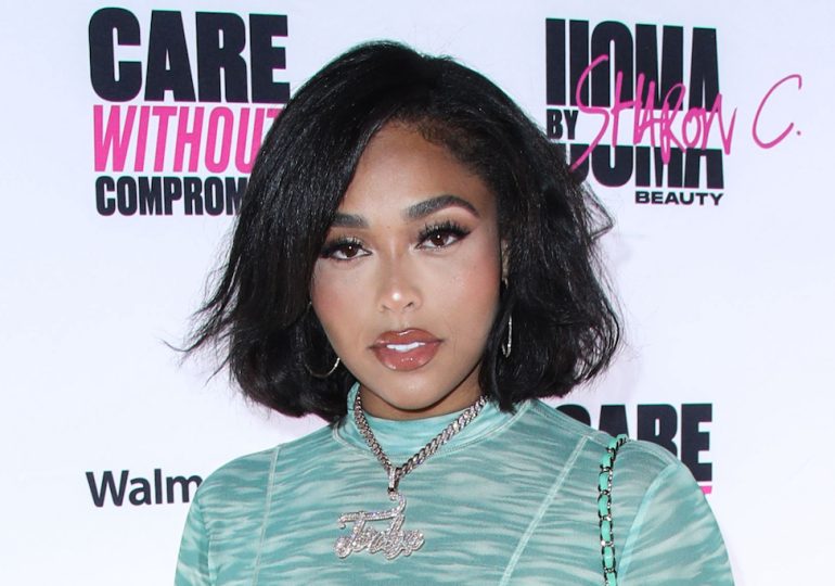 Jordyn Woods Delivers Cozy Beach Style in Knit Cardigan With Baggy Denim Jeans & Beaded Slides