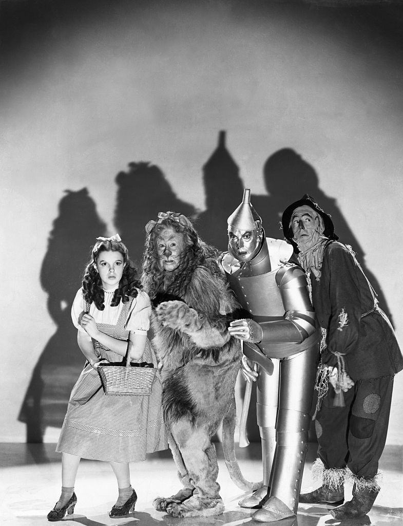 ruby slippers, Left to right: Judy Garland, Bert Lahr, Jack Haley, and Ray Bolger dressed in character as Dorothy Gale, Cowardly Lion, Tin Man, and Scarecrow from the film The Wizard of Oz.